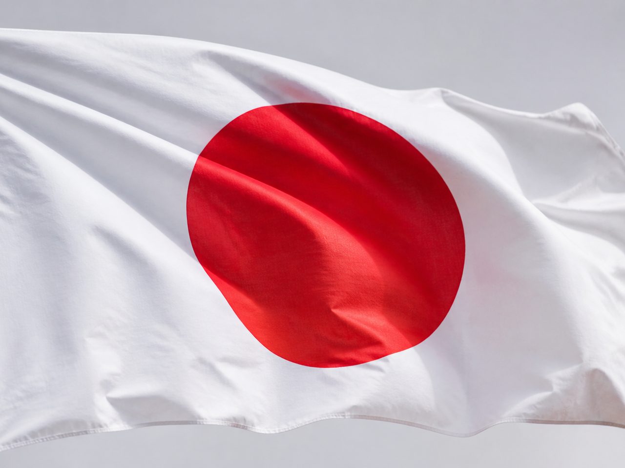 The national flag of Japan flying against the sky
