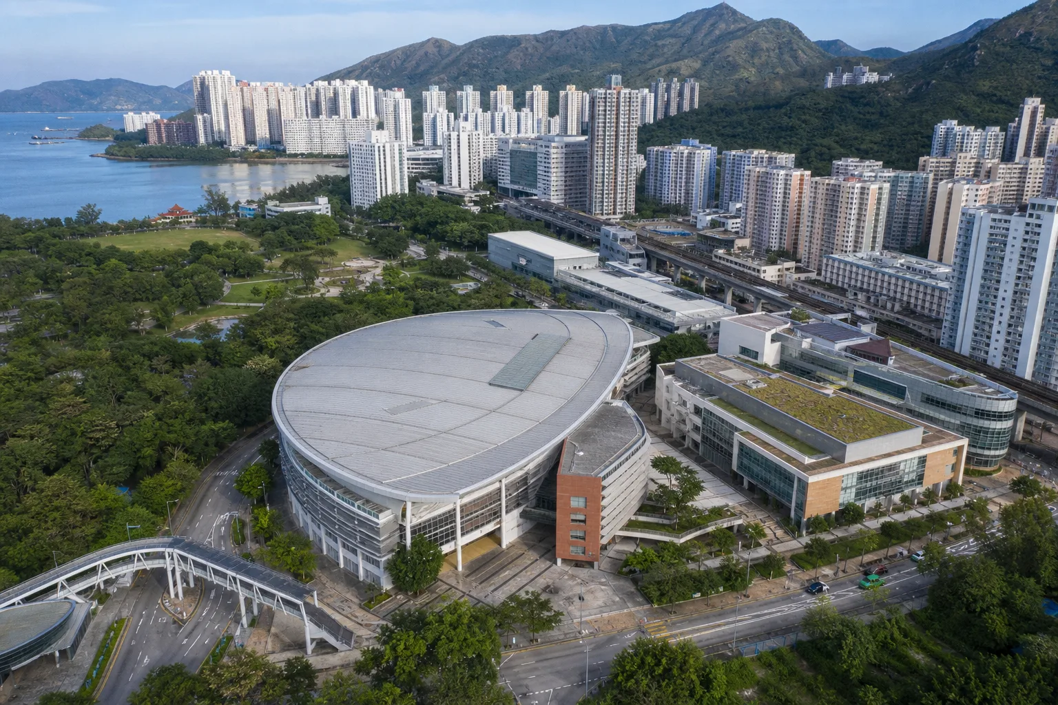 Aerial editorial image of Ma On Shan Sports Centre area, with Tolo Harbour, residential towers and green hills in the background.