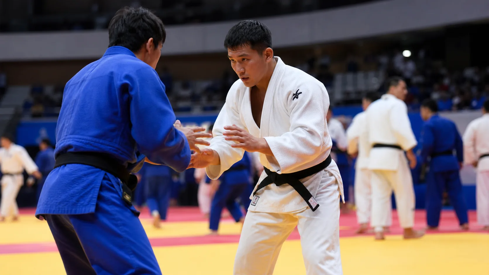 Editorial judo news image showing athletes preparing on tatami at an international arena
