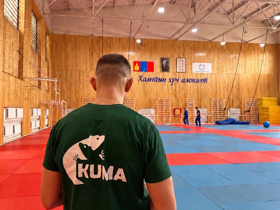 Kuma T-shirt from behind inside an Ulaanbaatar judo venue for an IJF World Judo Tour spectator guide