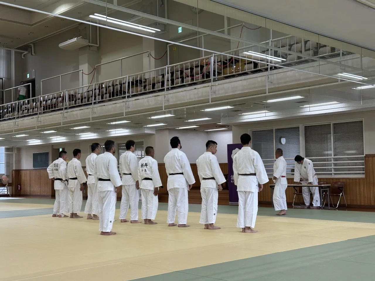 Judoka lining up inside a Kodokan dojo for an event