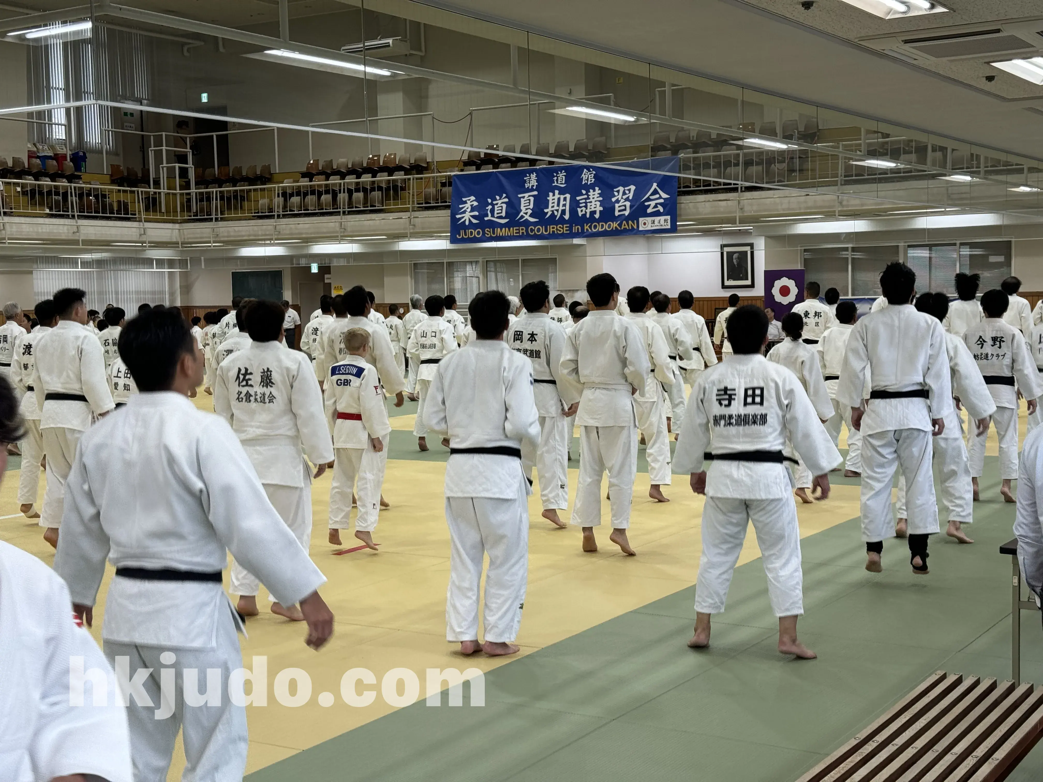 講道館少年柔道暑期講習會 — 講習會於館內道場集合，背景為「柔道夏期講習會」橫額