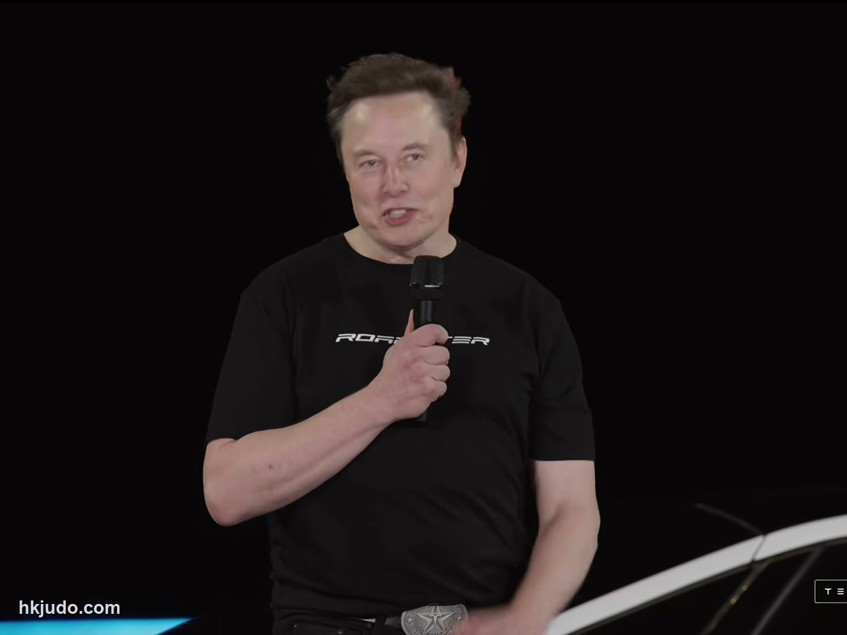 編集画像：Tesla Roadster発表会のステージでマイクを手に話すイーロン・マスク